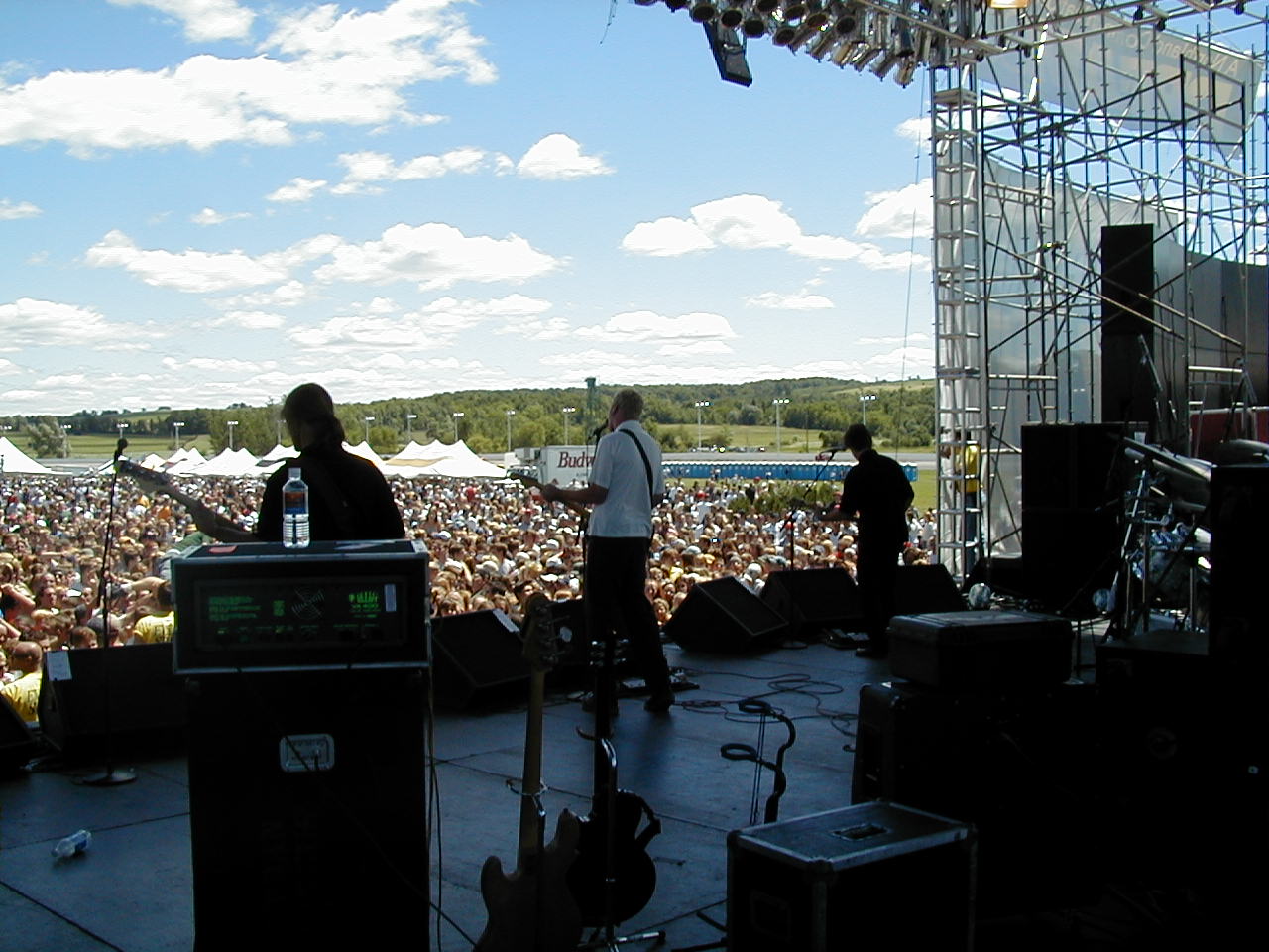 The Uninvited, an American band, perform on stage in front of a huge crowd on a sunny day